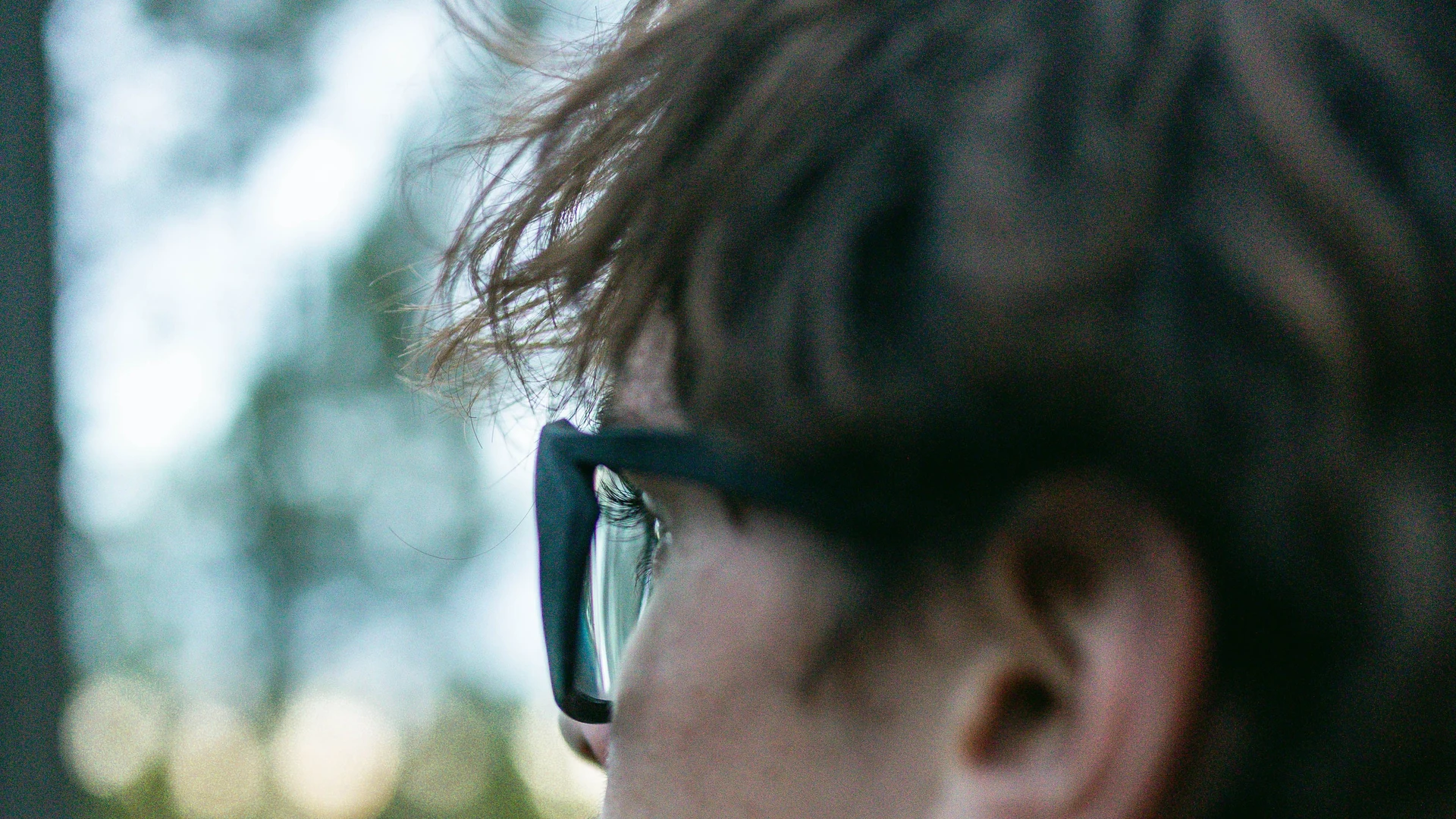 Young man wearing LLUM Spectacles and looking into the distance.