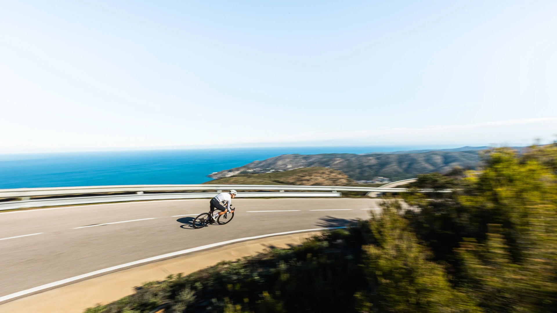 Athletic cyclist on the road with a view of the ocean.