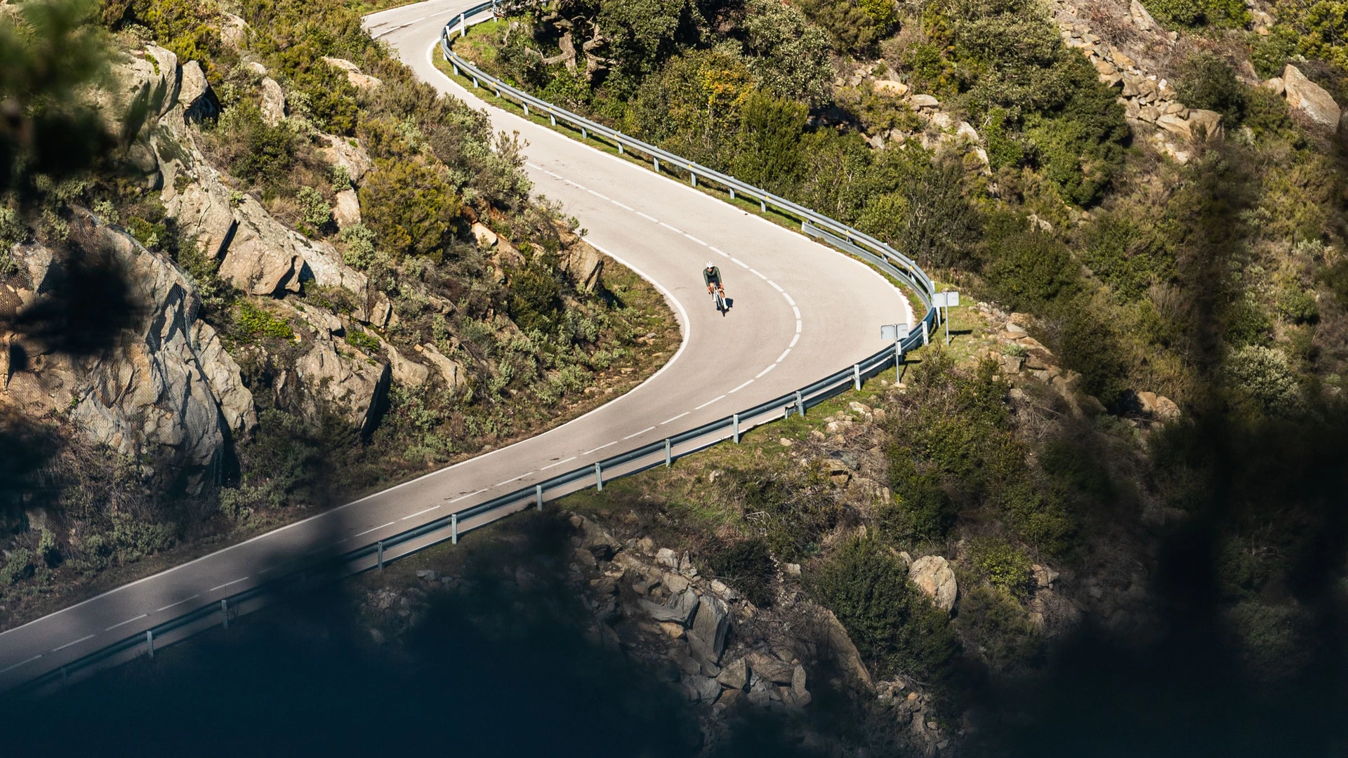 Cyclist driving down a mountain road.